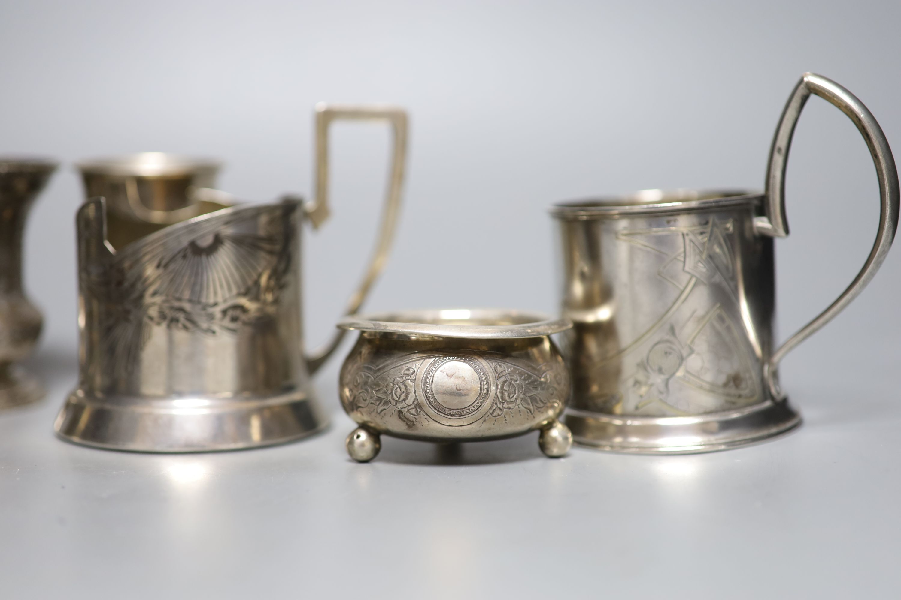 A group of six Russian early 20th century 84 zolotnik podstakanniks, two small vases, two tots and a salt